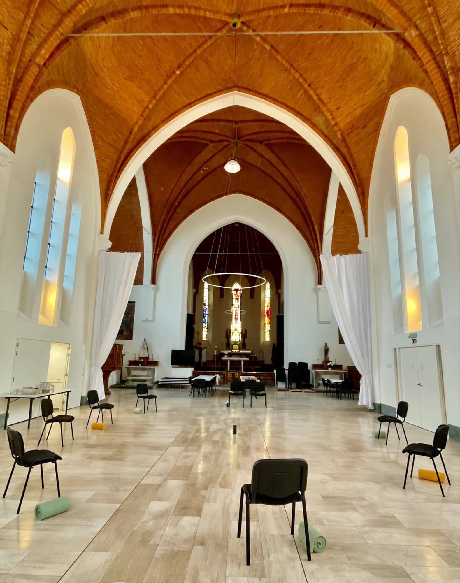 Een lichte kerkzaal met stoelen in een kring, klaar voor een opstellingsdag
